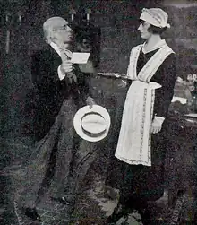 stage scene: left, an old white man with receding white hair, handing a letter to a housemaid