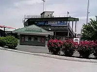 Entrance showing ticket booth and press box at top of grandstand