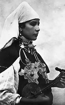 Image 3A Berber musician wearing two large triangular brooches in southern Morocco (early 20th century photo) (from Culture of Morocco)