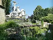 Profile view of complex showing cascade and dappling effect of reflections from the pool on the horses' wings