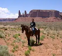 Image 36A Navajo boy in the desert in present-day Monument Valley in Arizona with the Three Sisters in the background in 2007 (from Indigenous peoples of the Americas)