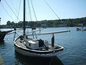 Nellie at a pier viewed from her port stern quarter.