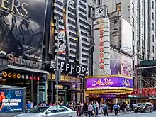 The facade of the theater as seen from across the street. The musical Aladdin is being advertised on the marquee.