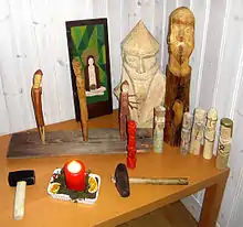 A wooden table indoors on which have been placed wooden icons