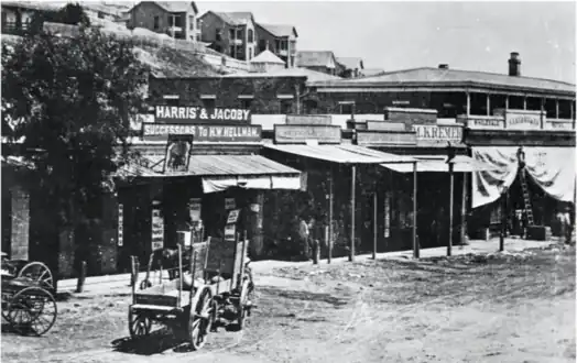 Sign for "Harris & Jacoby, successors to H. W. Hellman",  forerunner to both Harris & Frank and Jacoby Bros., in the Old Downey Block around 1870. At right are signs for M. Kremer’s and S. Lazard’s stores, both forerunners of the City of Paris department store