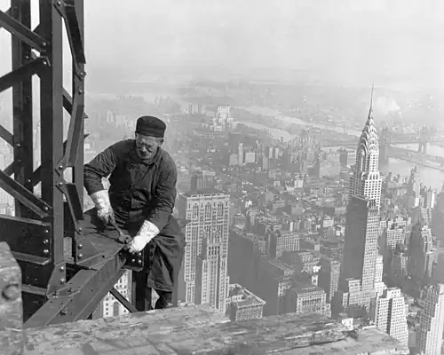 Image 7A workman helps raise the Empire State Building 25 floors higher than the Chrysler Building (at right), as seen in 1931. (from History of New York City (1898–1945))