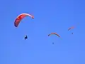 Several kites in free flight; paraglider kites can remain kiting in thermal and slope updrafts for hours.