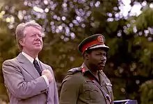 Carter standing alongside Olusegun Obasanjo outside.