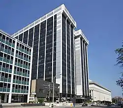 A tall, white, steel-framed building with black windows.