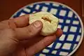 Dough being wrapped around a piece of fruit