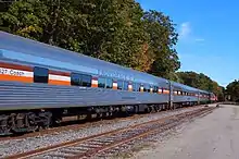 A passenger train is seen, primarily its stainless steel coaches, which have the name "PROVIDENCE & WORCESTER" on their sides, and are named after the states P&W serves, including Connecticut, Rhode Island, and Massachusetts.