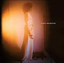 A woman in a white dress stands in front of a white background. An orange light is being shone on her. To the right, white block capital text reads "PJ Harvey When Under Ether."