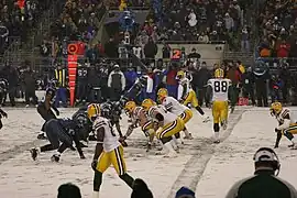 Packers and Seahawks players lining up before the snap on a snowy football field