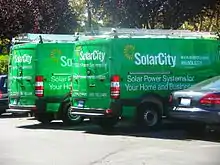 Two green vans sporting the SolarCity logo