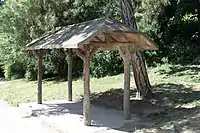 A rain shelter, made of concrete hand sculpted to look like wood in a technique known as "faux bois"