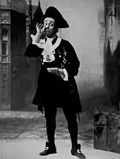 White man in frock coat, tricorn hat and knee britches, taking snuff