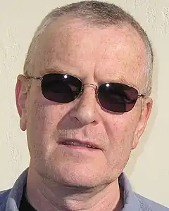 Photographic face portrait of Condell with sun glasses on.