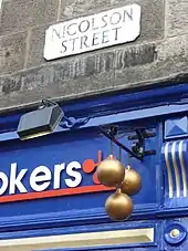 Blue, white and red sign, with three gold balls