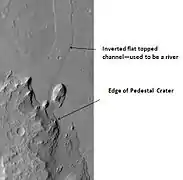 Pedestal Crater and ridge in Oxia Palus quadrangle, as seen by HiRISE.  Click on image to see detail of the edge of the pedestal crater.  The flat-topped ridge near the top of the image was once a river that became inverted.  The pedestal crater superposes the ridge, so it is younger.