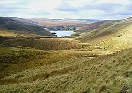 A view across moorland down to a reservoir