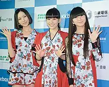 Three women on stage at a music concert