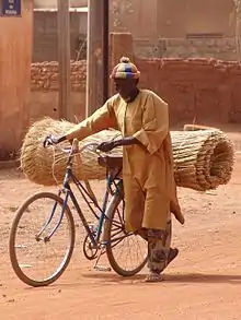 A man uses a bicycle to carry goods in Ouagadougou, Burkina Faso