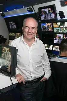 A portrait photo of Peter Hutton in front of some screens.