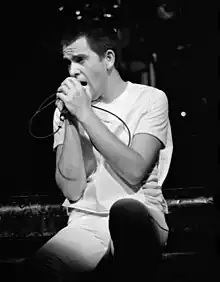 Black and white photograph of Gabriel singing in concert