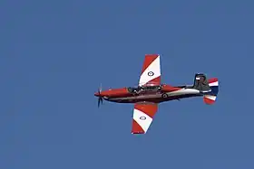 Single-engined aircraft with red-and-white livery, in flight