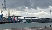 A view of the Port of Ipswich, showing a medium sized cargo vessel entering port under the Orwell Bridge.