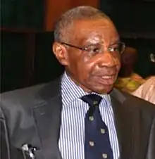 Justice Dahiru in a black suit and a stripped blue shirt