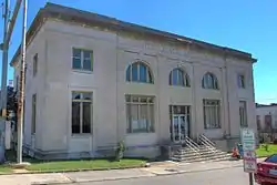 Two-story building fronted with staircase and arched windows