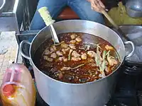 A pot of bún bò broth with rice noodles being cooked separately at a Ho Chi Minh City eatery