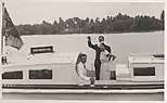 Prince Philip waves goodbye as he and Queen Elizabeth, accompanied by John Clunies-Ross, return to their ship from Home Island (1954).