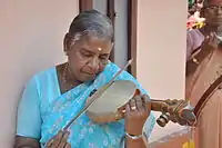 Woman playing a Pulluvan vina.