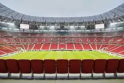 Photograph of a modern football stadium's interior; the stands are full of spectators