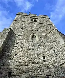 Large grey stone tower, seen from below