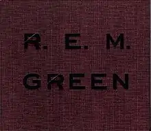 A crimson cover with rough-hewn texture that has "GREEN" and "R.E.M." debossed on it in black