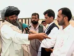 A reporter interviews a man in Helmand Province, Afghanistan, 2009.