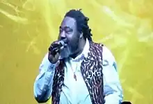 Veteran Nigerian Reggae artist Ras Kimono holding the mic