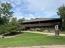 photo shows the exterior of a brown building titled "Red Oak Center" featuring outdoor foilage.