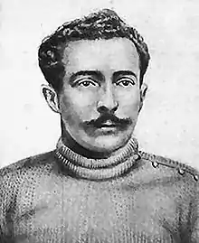 A black-and-white photograph of a man with a mustache.