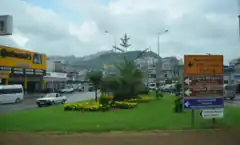 Photograph of an urban area. There are streets, road signs, and some green space.