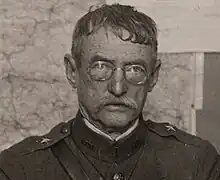 Black and White February 1919 head and shoulders photo of Brigadier General Robert D. Walsh in duty uniform seated at desk in France