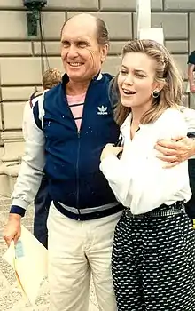 Picture of Robert Duvall smiling and looking to the left with his arm around fellow actor Diane Lane in 1989