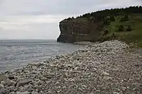 The pebble beach of Lance Cove with a cliff in the background