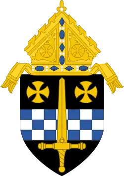 An image of a coat of arms: a golden sword laid over a fess chequy blue and silver and two gold rounded crosses pattée in chief, with a bishop's mitre surmounting the shield.