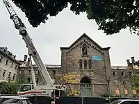 Photo showing the roof damage caused by the fire, nearly six months after it happened, with construction cranes in the foreground.