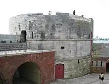 A front facing view of Portsmouth's Round Tower, which once guarded the entrance to Portsmouth Harbour. The Round Tower itself is made of stone and has a large circular base.