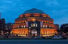 Image 37The Proms are held annually at the Royal Albert Hall during the summer. Regular performers at the Albert Hall include Eric Clapton who has played at the venue over 200 times. (from Culture of the United Kingdom)